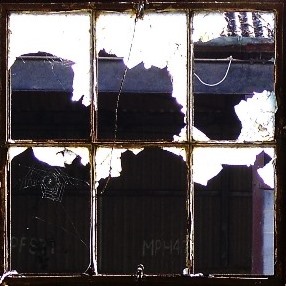 A window clings to its last fragments of glass.